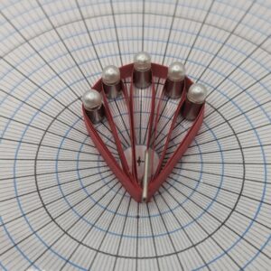 Quilling board with pins inserted into metal adapters to show loop size control.